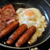 Egg, sausages and bacon being fried in a frying pan