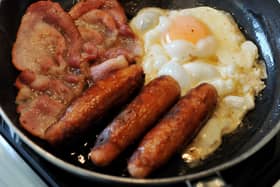Egg, sausages and bacon being fried in a frying pan