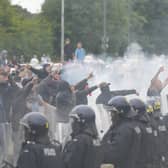 Police officers face protesters during an anti-immigration demonstration outside the Holiday Inn Express in Rotherham