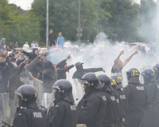 Police officers face protesters during an anti-immigration demonstration outside the Holiday Inn Express in Rotherham