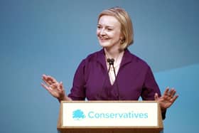Liz Truss smiles at one of her own jokes: that she served as UK Prime Minister (Picture: Christopher Furlong/Getty Images)