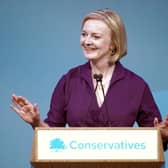 Liz Truss smiles at one of her own jokes: that she served as UK Prime Minister (Picture: Christopher Furlong/Getty Images)