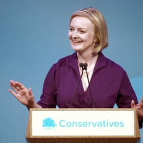 Liz Truss smiles at one of her own jokes: that she served as UK Prime Minister (Picture: Christopher Furlong/Getty Images)