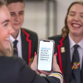 Students at Lochgelly High School in Lochgelly, Fife, check their results on a smart phone