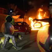 A police car burns as officers in riot gear restore order to the streets of Hartlepool (Picture: Owen Humphreys/PA)