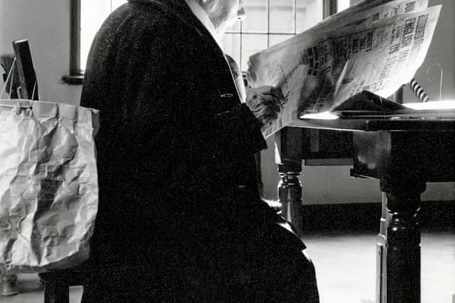 Woman with a newspaper in Ward Rd Reading Room, 1960s.