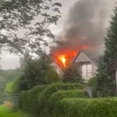 Flames pour from house roof after it’s struck by lightning.