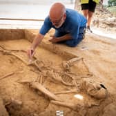 Belgian archaeologist Dominique Bosquet working on a human skeleton found in 2022 at the site of the Battle of Waterloo in Belgium. Picture: Chris van Houts/Waterloo Uncovered/PA Wire