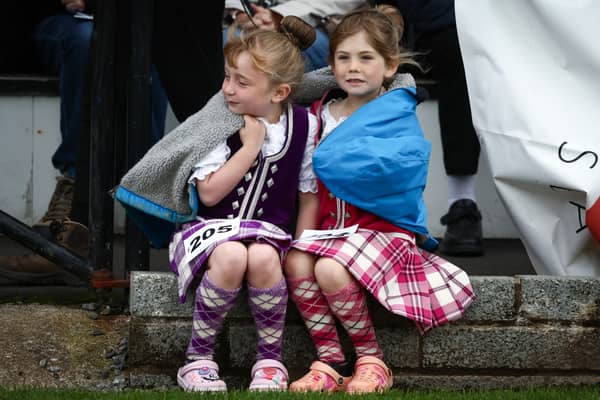 Two young dancers wrap up to keep warm at the Oban Games today
