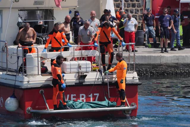 A body bag is brought ashore at the harbour in Porticello by rescue workers on the fifth day of the search and recovery operation, after the luxury yacht Bayesian sank in a storm on Monday whilst moored around half a mile off the coast of Porticello, Sicily
