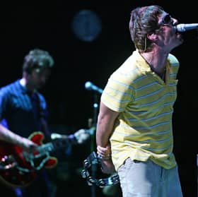 Liam (R) and Noel Gallagher perform on stage. Photo: JOSE JORDAN/AFP via Getty Images