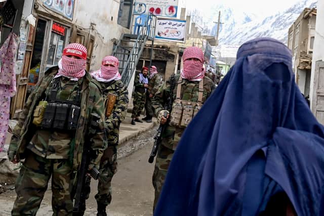 Taliban security personnel stand guard as an Afghan woman visits a market in the Baharak district of Badakhshan (Picture: Wakil Kohsar)