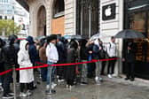 People queue in the rain at an Apple Store in Paris. Photo: MIGUEL MEDINA/AFP via Getty Images