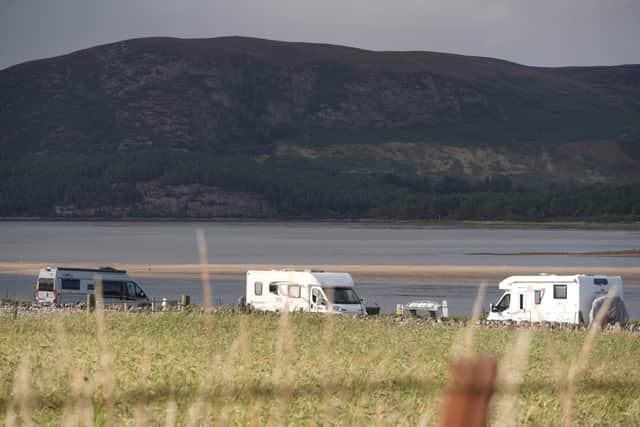 Campervans and motorhomes at Loch Fleet, a popular spot for visitors to pull up and admire views on the NC500