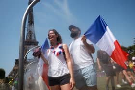 Spectators cool off under water misters in front of the Eiffel Tower on day four of the Paris Olympic Games  (Picture: Maja Hitij)