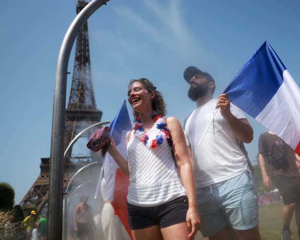 Spectators cool off under water misters in front of the Eiffel Tower on day four of the Paris Olympic Games  (Picture: Maja Hitij)