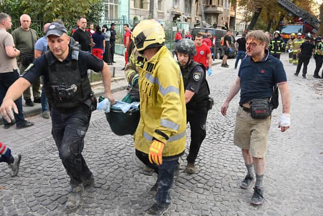 Jaroslav Bazylevych, right, follows Ukrainian emergency services personnel carrying the body of his daughter, who was killed along with her two sisters and their mother during a missile attack in Lviv on Wednesday (Picture: Yuriy Dyachyshyn)