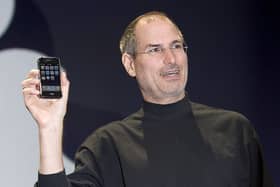 Apple CEO Steve Jobs holds up the new iPhone that was introduced at Macworld on January 9, 2007, in San Francisco, California. It was set to be the first in many itinerations of the touch screen mobile device.
