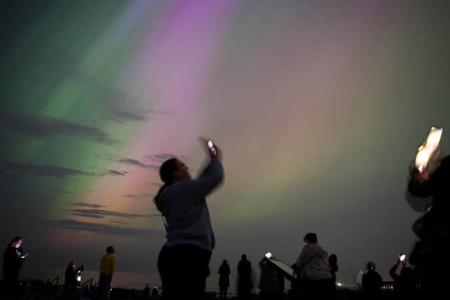 People take out their phones to try and capture the Northern Lights on camera. The natural lightshow may be visible again on Monday night in Scotland. Picture: Ian Forsyth/Getty Images