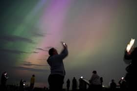 People take out their phones to try and capture the Northern Lights on camera.