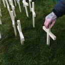A man leaves a cross for his brother during an event to mark those who lost their lives to drugs in Scotland at Springburn Parish Church in Glasgow