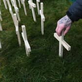 A man leaves a cross for his brother during an event to mark those who lost their lives to drugs in Scotland at Springburn Parish Church in Glasgow