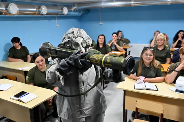Ukrainian civilians watch a demonstration of an anti-tank grenade launcher during military training in the Kharkiv region of Ukraine earlier this month (Picture: Sergey Bobok)