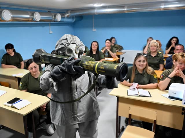 Ukrainian civilians watch a demonstration of an anti-tank grenade launcher during military training in the Kharkiv region of Ukraine earlier this month (Picture: Sergey Bobok)