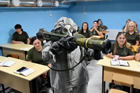 Ukrainian civilians watch a demonstration of an anti-tank grenade launcher during military training in the Kharkiv region of Ukraine earlier this month (Picture: Sergey Bobok)