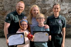 Arianna Liddle (centre), her brother Oliver (centre right) and their mother, Donna (second right), with Scottish Ambulance Service staff. Picture: Scottish Ambulance Service/SWNS