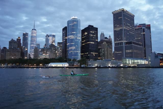 Andy Donaldson swimming in front of the Manhattan backdrop
