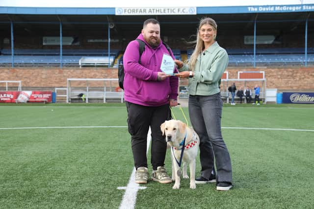 Jon Attenborough and his Labrador Sam with the SPFL's Molly Hyde at Station Park, Forfar. Picture: SPFL/Christopher Coutts/SWNS