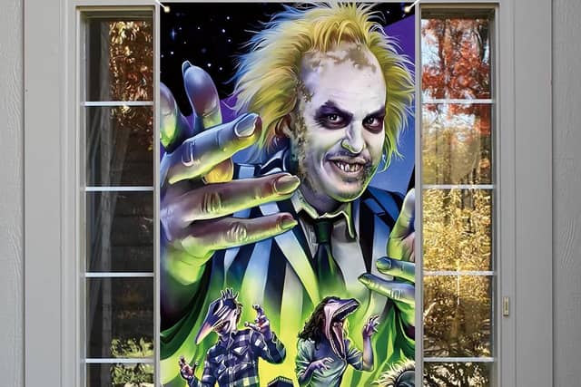Beetlejuice themed Halloween decorations like this door cover are all the rage this year