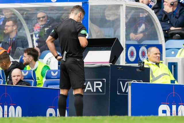 Referee Nick Walsh checks the VAR monitor during a match between Rangers and Hibs at Ibrox last season.