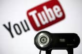 File photo of a camera positioned in front of YouTube's logo. Photo: LIONEL BONAVENTURE/AFP via Getty Images