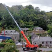 A truck is removed by a crane after getting stuck on a narrow lane in Forder near Saltash, Cornwall.
