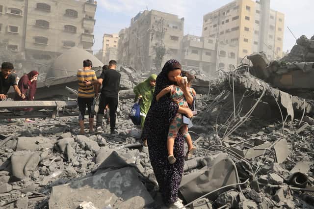 Palestinian civilians evacuate the area following an Israeli airstrike on the Sousi mosque in Gaza City in October last year (Picture: Mahmud Hams)