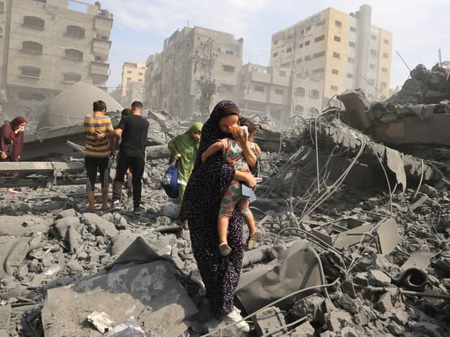 Palestinian civilians evacuate the area following an Israeli airstrike on the Sousi mosque in Gaza City in October last year (Picture: Mahmud Hams)