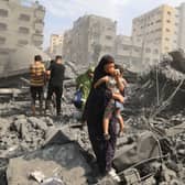 Palestinian civilians evacuate the area following an Israeli airstrike on the Sousi mosque in Gaza City in October last year (Picture: Mahmud Hams)