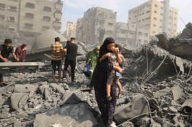Palestinian civilians evacuate the area following an Israeli airstrike on the Sousi mosque in Gaza City in October last year (Picture: Mahmud Hams)