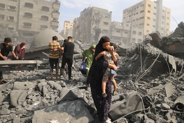 Palestinian civilians evacuate the area following an Israeli airstrike on the Sousi mosque in Gaza City in October last year (Picture: Mahmud Hams)