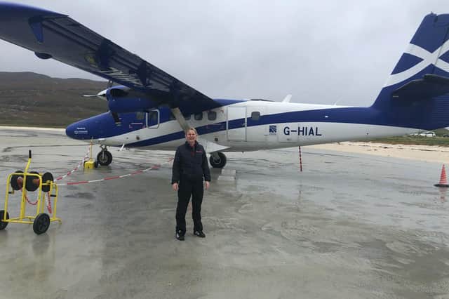 Loganair Barra station manager Dolina Manford beside a Twin Otter aircraft which flies there twice daily from Glasgow