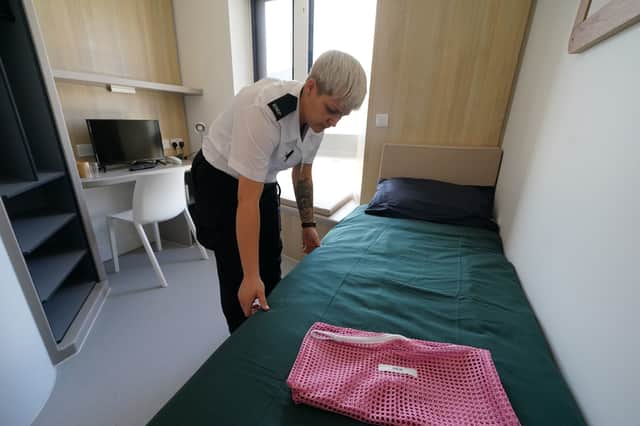 A prison officer adjusts the bedding inside a room in HMP and YOI Stirling, which houses remand and convicted young and adult women
