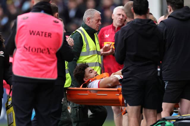 Andy Onyeama-Christie of Saracens is carried off after being injured during the Gallagher Premiership match against Harlequins.