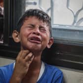 A Palestinian boy mourns relatives killed in Israeli missile strikes in the central Gaza Strip last month (Picture: Eyad Baba)