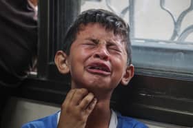 A Palestinian boy mourns relatives killed in Israeli missile strikes in the central Gaza Strip last month (Picture: Eyad Baba)