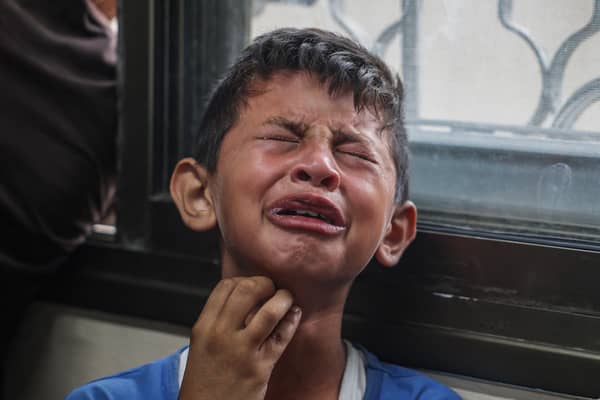 A Palestinian boy mourns relatives killed in Israeli missile strikes in the central Gaza Strip last month (Picture: Eyad Baba)