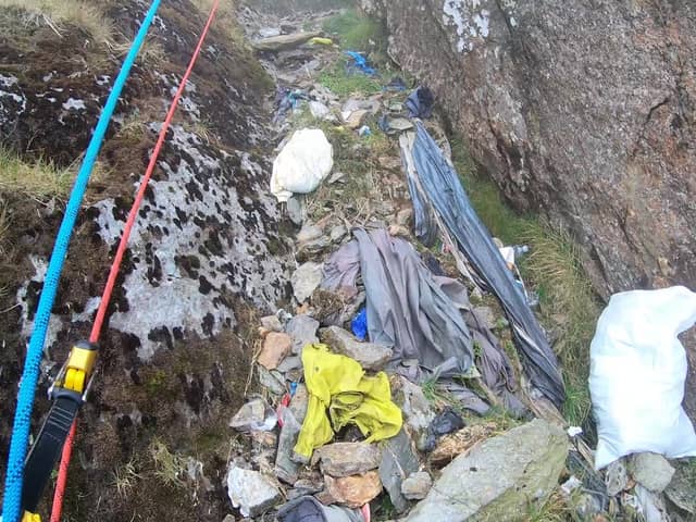 Video grab from heartbreaking footage showing 'waterfalls' of 3,000 bits of rubbish including drinks cans and Santa hats left by people on Mount Snowdon.