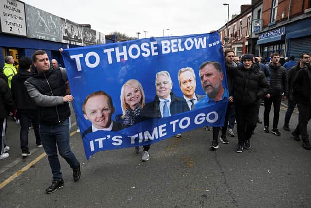 Everton fans protest hold a banner reading "It's time to go..." with portraits of club owner Farhad Moshiri (2ndR) and board members (from L) Grant Ingles, Denise Barrett-Baxendale, Bill Kenwright and  Sharp.