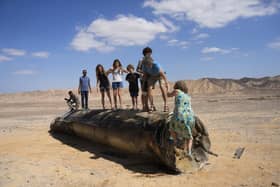 People climb on the debris of an Iranian missile intercepted by Israel, near Arad, southern Israel, on 2 October